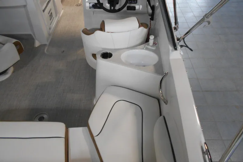 Slide: The Image of 2025 Stingray 201 DC boat interior with seating, steering wheel, and sink. - 9