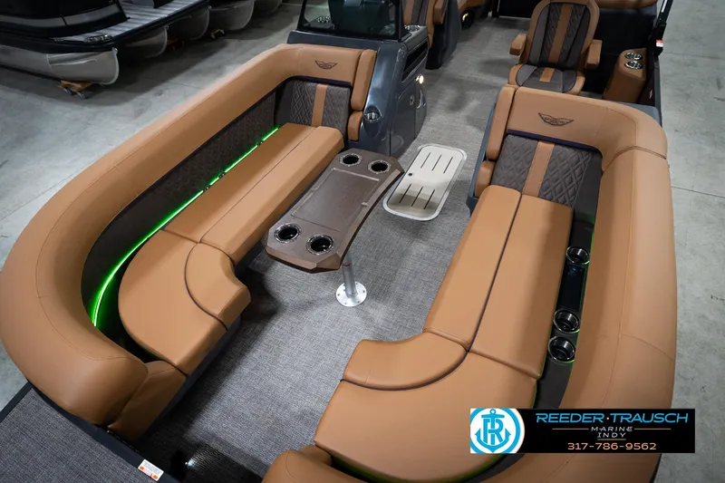 Slide: The Image of 2026 Bennington 22 MFB pontoon boat in showroom with canopy and tan seating. - 11