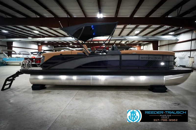 Slide: The Image of 2026 Bennington 22 MFB pontoon boat displayed indoors at Reeder-Trausch Marine showroom. - 6