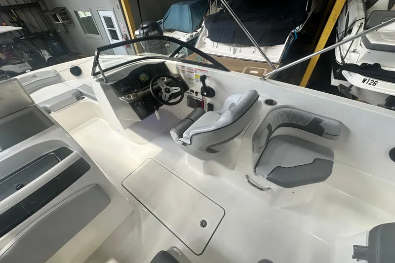 Slide: The Image of 2024 Bayliner VR6 Bowrider OB interior with modern seating and steering console. - 12