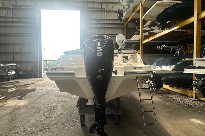 Slide: The Image of 2024 Bayliner VR6 Bowrider OB in storage, rear view with outboard motor. - 9