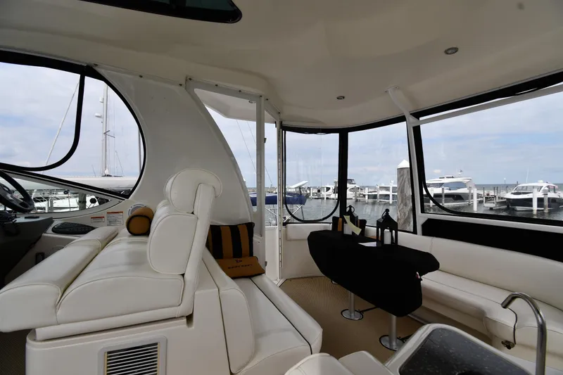 Slide: The Image of Interior of 2007 Cruisers Yachts 455 Express Motoryacht with white seating and marina view. - 21