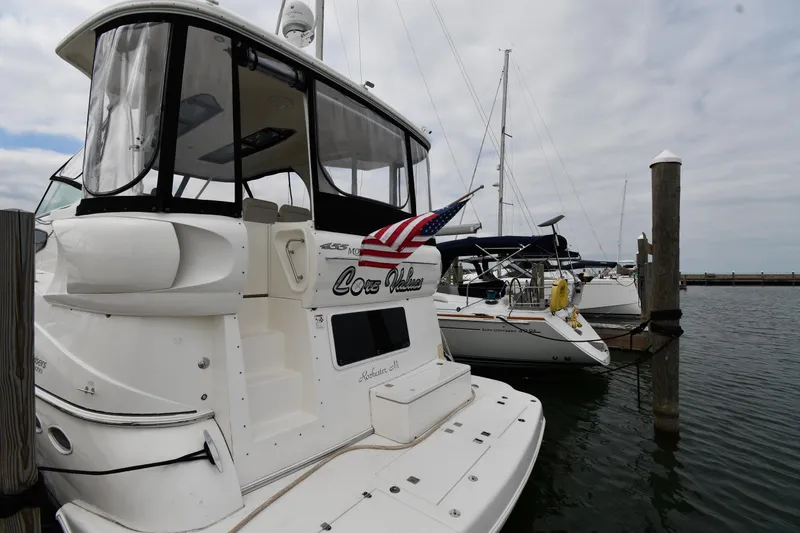 Slide: The Image of 2007 Cruisers Yachts 455 Express Motoryacht docked at marina with American flag. - 3