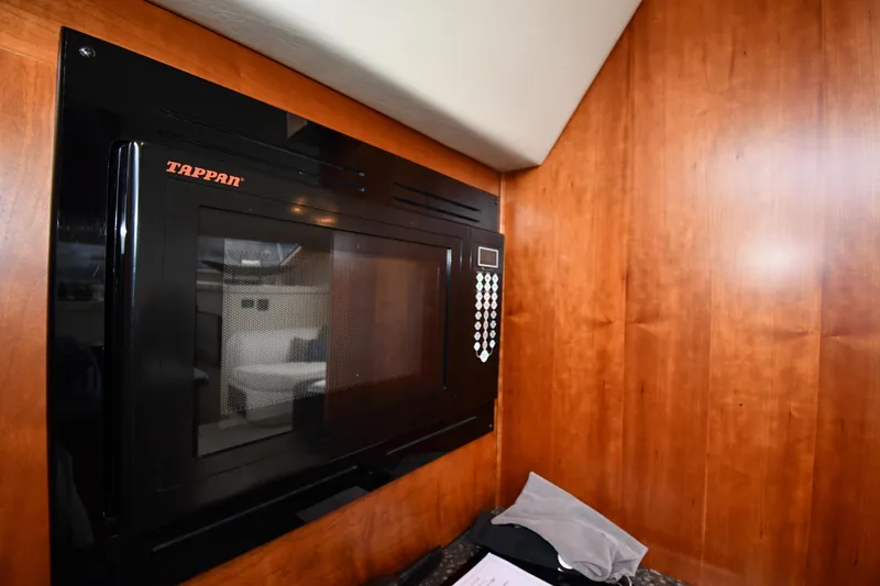 Slide: The Image of Tappan microwave in 2007 Cruisers Yachts 455 Express Motoryacht kitchen, wood paneling background. - 51