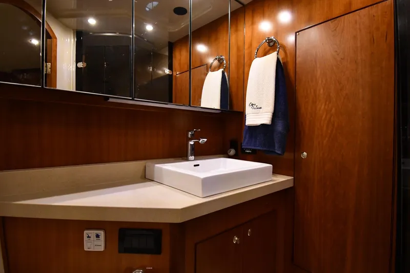 Slide: The Image of Luxurious bathroom in 2007 Cruisers Yachts 455 Express Motoryacht with modern sink and wooden cabinetry. - 63