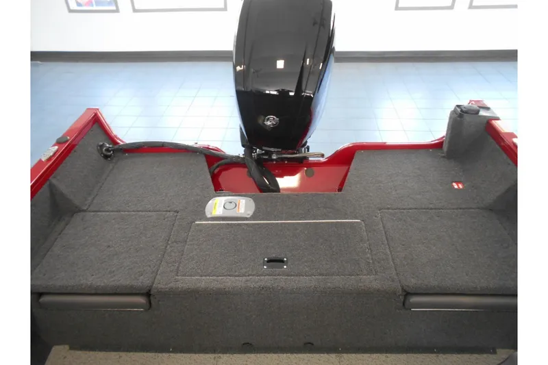 Slide: The Image of 2025 Crestliner 1650 Fish Hawk SC JS boat interior with motor, gray carpeted deck. - 14