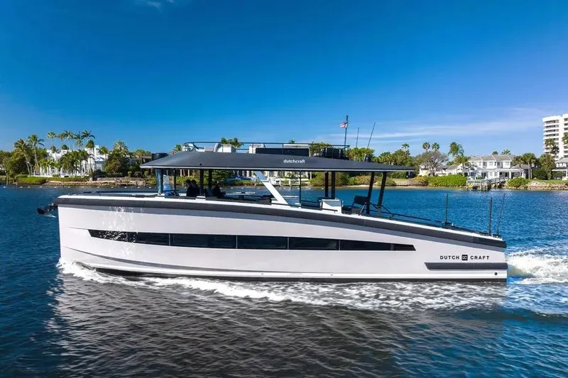 Slide: The Image of 2019 DutchCraft 56 Open yacht cruising on a sunny day near waterfront homes. - 1