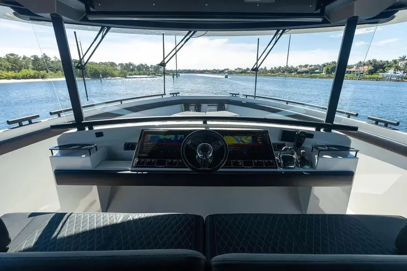 Slide: The Image of Cockpit view of 2019 DutchCraft 56 Open yacht, featuring modern navigation controls and scenic waterway. - 13