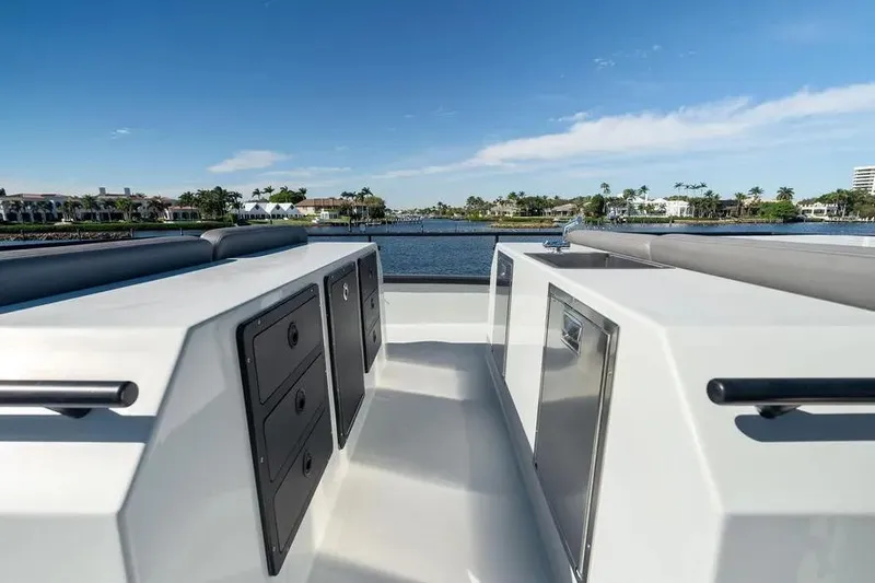 Slide: The Image of 2019 DutchCraft 56 Open yacht deck with storage, overlooking serene waterfront homes. - 18
