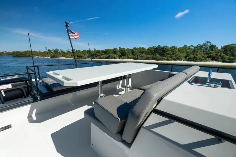 Slide: The Image of Luxurious 2019 DutchCraft 56 Open yacht deck with seating and table, overlooking serene waters. - 22