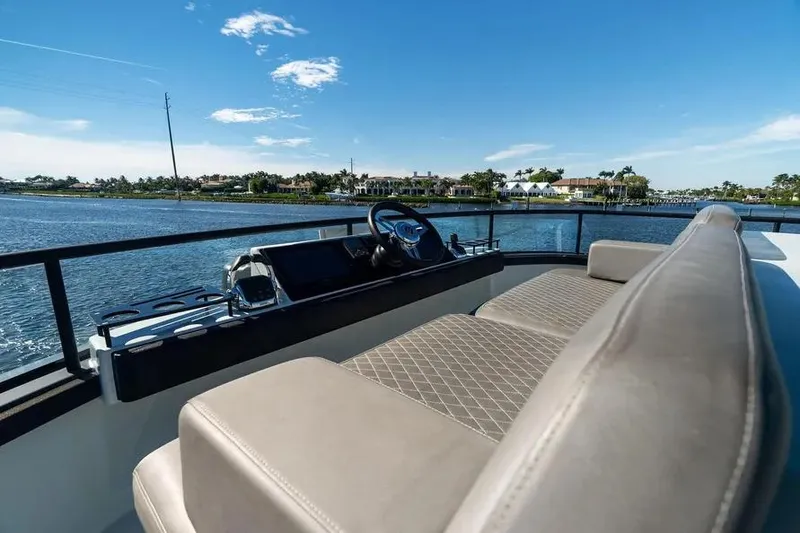 Slide: The Image of 2019 DutchCraft 56 Open yacht interior with steering wheel, overlooking serene waterfront. - 24