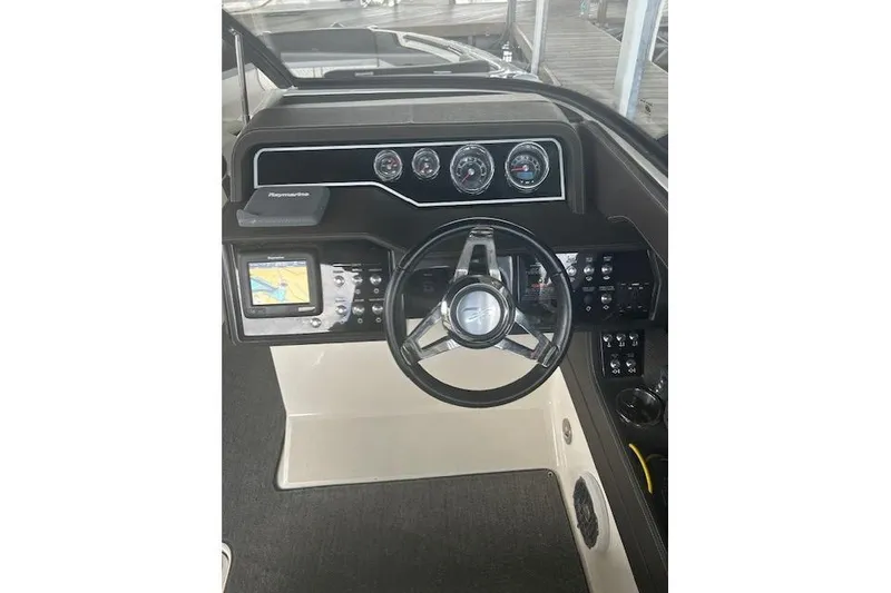 Slide: The Image of 2017 Sea Ray SLX 280 helm with steering wheel, gauges, and navigation display. - 4