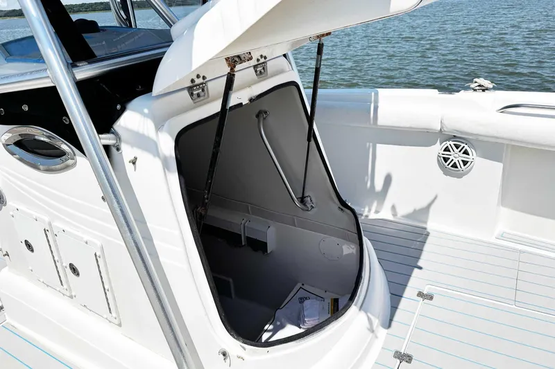 Slide: The Image of 2005 Wellcraft 32 CCF boat with open storage compartment, docked on calm water. - 18