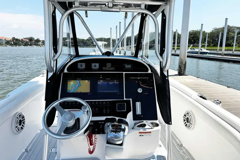 Slide: The Image of 2005 Wellcraft 32 CCF boat dashboard with navigation screens and steering wheel at marina. - 25