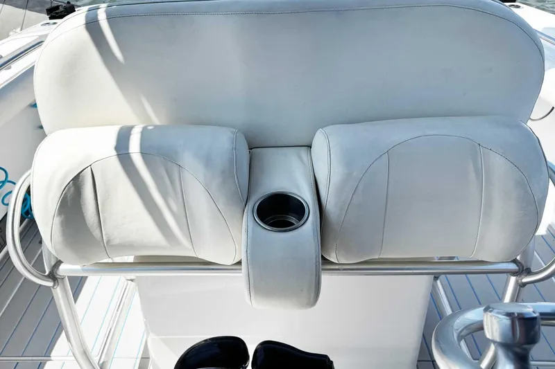 Slide: The Image of 2005 Wellcraft 32 CCF boat seating with cup holder, featuring white cushioned seats. - 40