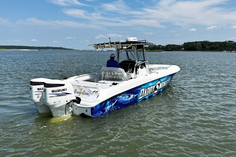 Slide: The Image of 2005 Wellcraft 32 CCF boat with Suzuki engines on water, vibrant graphics, clear sky. - 6