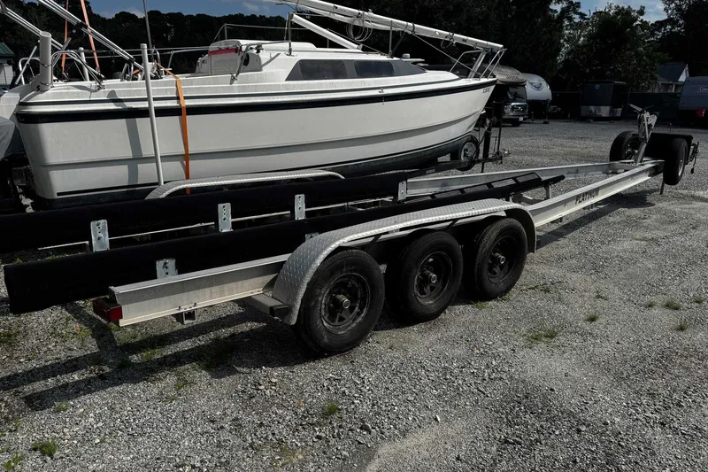 Slide: The Image of 2005 Wellcraft 32 CCF boat on a triple-axle trailer in a gravel lot. - 61