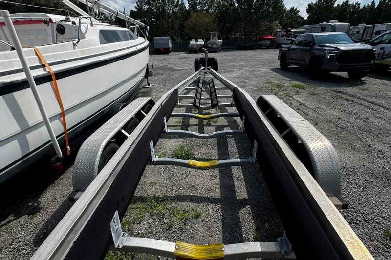 Slide: The Image of Boat trailer parked beside a Wellcraft 32 CCF, 2005 model, in a gravel lot. - 63