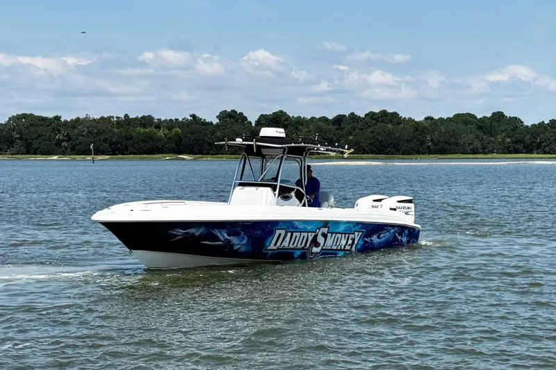 Slide: The Image of 2005 Wellcraft 32 CCF boat cruising on a calm lake with scenic forest backdrop. - 7