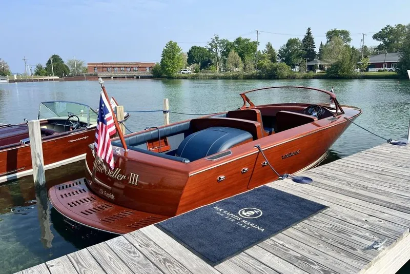 Slide: The Image of Luxurious 2026 Verano V25 boat docked at a serene marina with American flag. - 1