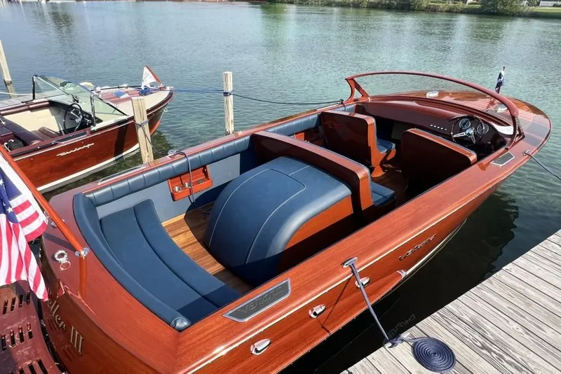 Slide: The Image of Luxury Verano V25 boat, 2026 model, docked on a serene lake with elegant wood finish. - 2