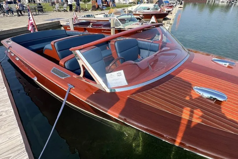 Slide: The Image of Luxury Verano V25 boat, 2026 model, with sleek wooden finish and blue interior, docked by the water. - 4