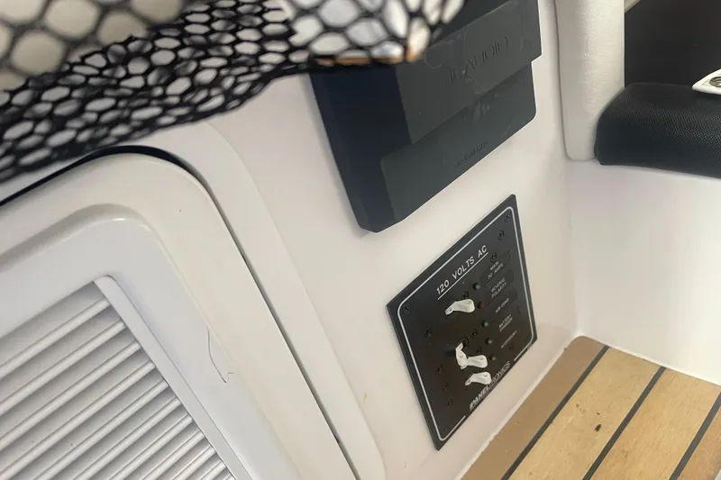 Slide: The Image of 2023 Nor-Tech 390 Sport boat interior with electrical panel and JL Audio system. - 14