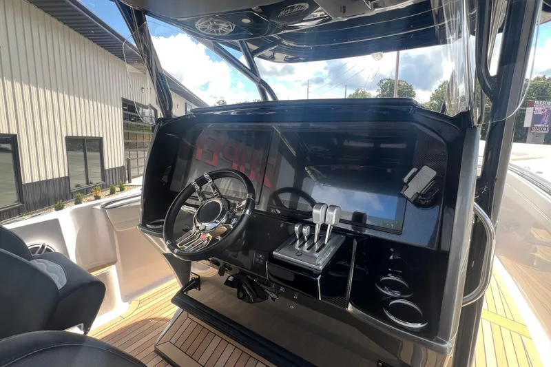 Slide: The Image of 2023 Nor-Tech 390 Sport boat dashboard with steering wheel and controls. - 6