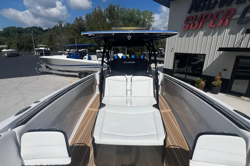 Slide: The Image of 2023 Nor-Tech 390 Sport boat with sleek design and comfortable seating at a dealership. - 7