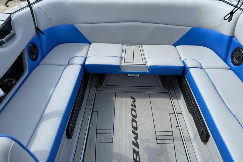 Slide: The Image of 2023 Moomba Max boat interior with blue and gray seating, featuring built-in speakers. - 12