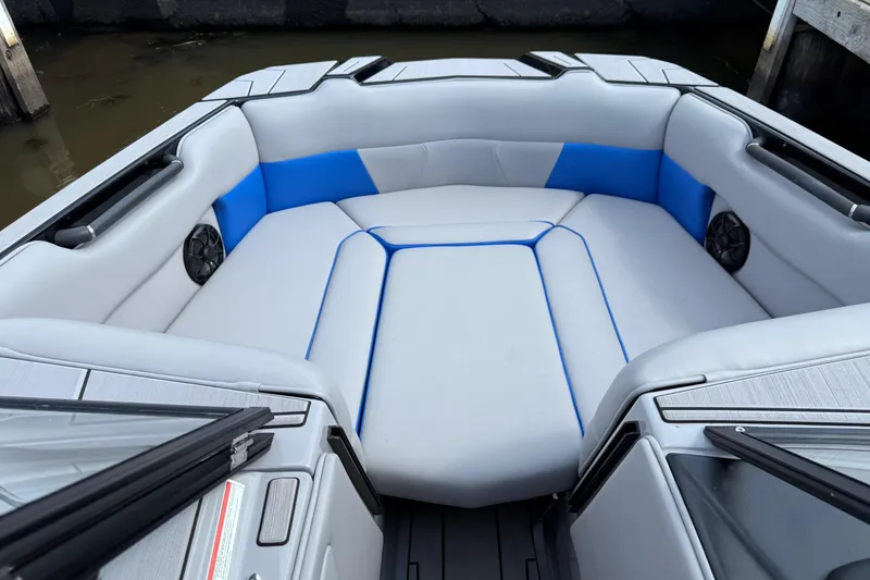 Slide: The Image of 2023 Moomba Max boat interior with gray and blue seating, featuring built-in speakers. - 13