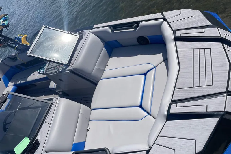 Slide: The Image of 2023 Moomba Max boat interior with gray and blue seating, on a sunny day. - 18