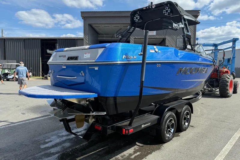 Slide: The Image of 2023 Moomba Max boat in blue, parked on a trailer outside a warehouse. - 4