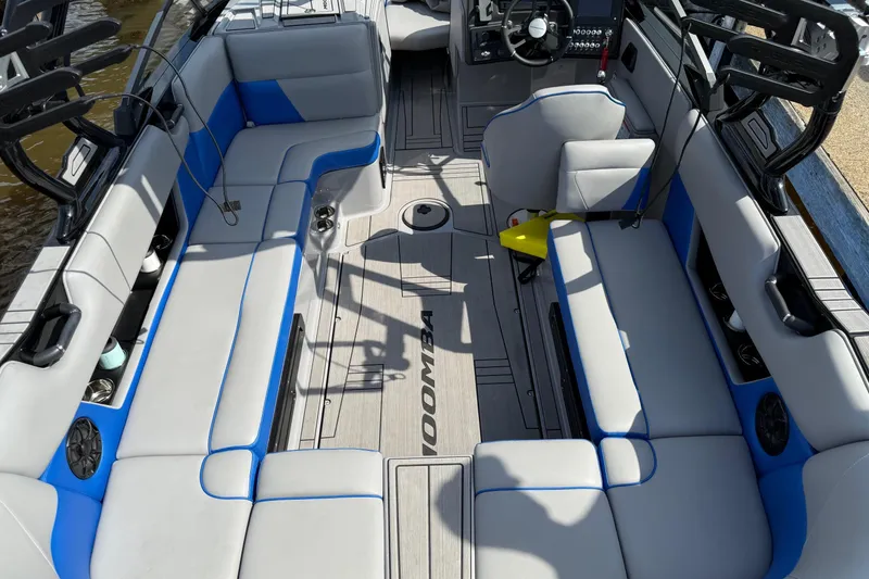 Slide: The Image of 2023 Moomba Max boat interior with gray and blue seating, modern design, and spacious layout. - 9
