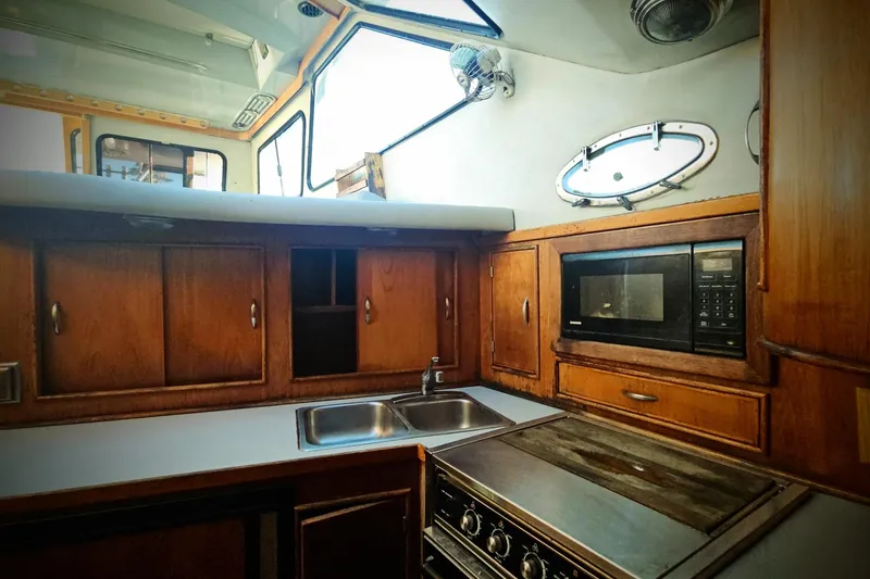 Slide: The Image of 1989 Mediterranean 38 Express yacht kitchen with wood cabinets, microwave, and stainless steel sink. - 16