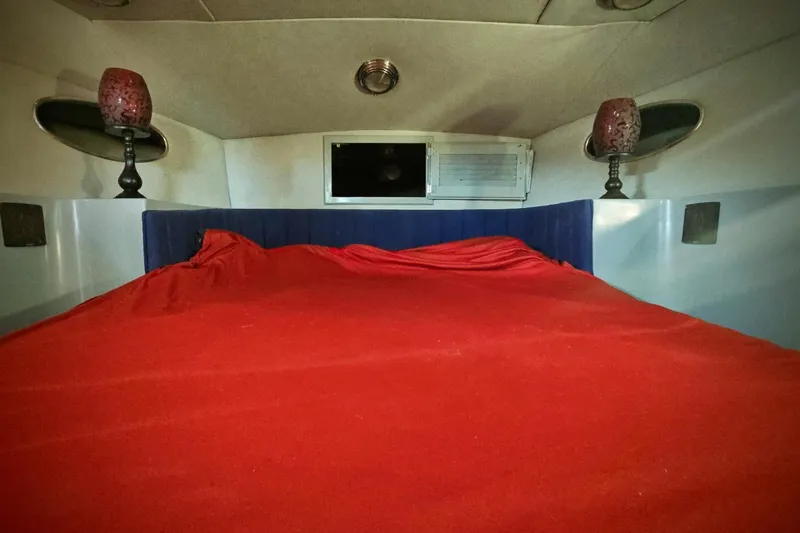 Slide: The Image of Interior cabin of 1989 Mediterranean 38 Express with red bedding and ambient lighting. - 17