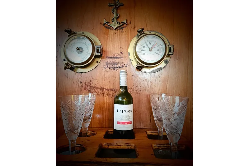 Slide: The Image of Vintage Mediterranean 38 Express yacht interior with wine bottle, crystal glasses, and nautical instruments. - 19