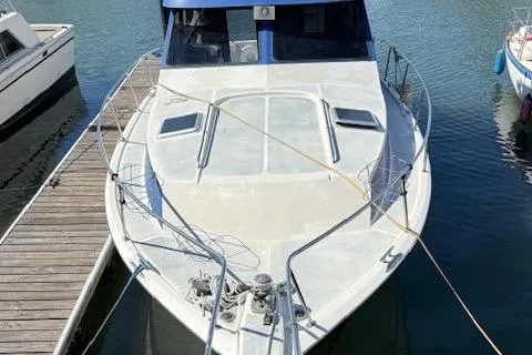 Slide: The Image of 1989 Mediterranean 38 Express boat docked at marina, front view. - 2