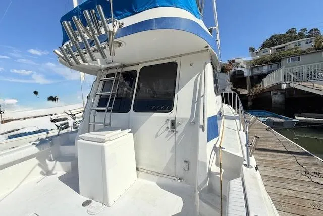 Slide: The Image of 1989 Mediterranean 38 Express yacht docked, featuring a ladder and blue accents. - 3