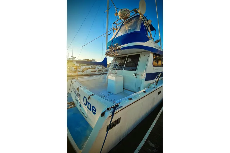 Slide: The Image of 1989 Mediterranean 38 Express boat docked at sunset, featuring blue and white design. - 4