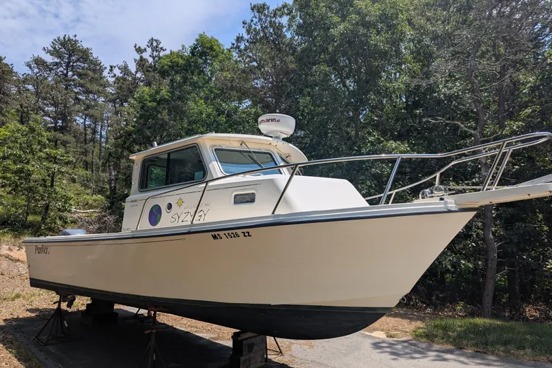 Slide: The Image of 2008 Parker 2520 Modified Vee Sport Cabin boat on stands, surrounded by trees. - 1
