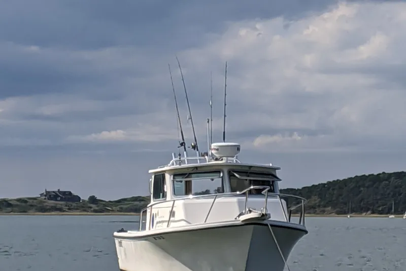 Slide: The Image of 2008 Parker 2520 Modified Vee Sport Cabin boat on calm water under cloudy sky. - 3