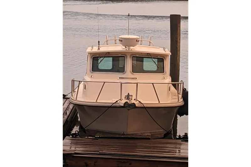 Slide: The Image of 2008 Parker 2520 Modified Vee Sport Cabin boat docked on calm water. - 6