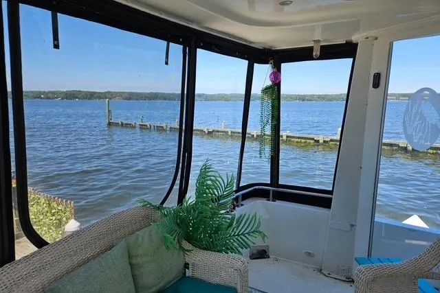 Slide: The Image of 2003 Carver 444 Cockpit Motor Yacht interior with wicker chair and lake view. - 14