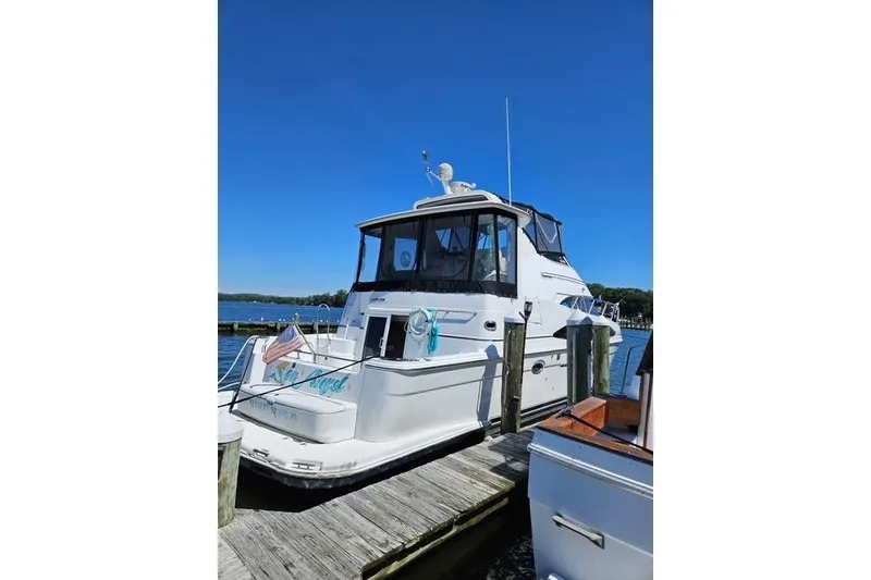 Slide: The Image of 2003 Carver 444 Cockpit Motor Yacht docked at a marina. - 2