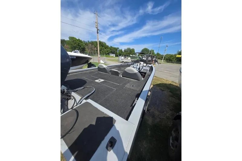 Slide: The Image of 2014 G3 Eagle Talon 19 DLX boat with spacious deck, parked outdoors under blue sky. - 12