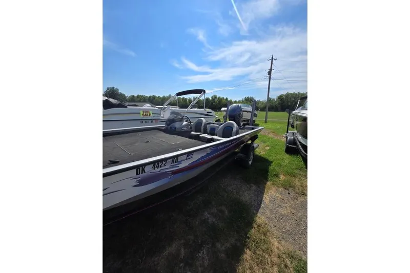 Slide: The Image of 2014 G3 Eagle Talon 19 DLX boat parked on grass under blue sky. - 2