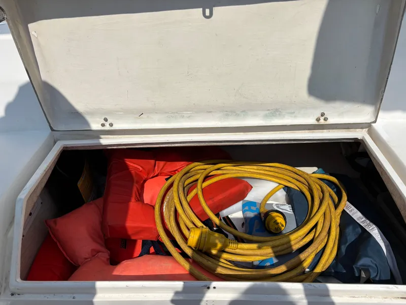 Slide: The Image of Open storage compartment on 1992 Catalina 34 with life jackets and yellow power cord. - 37