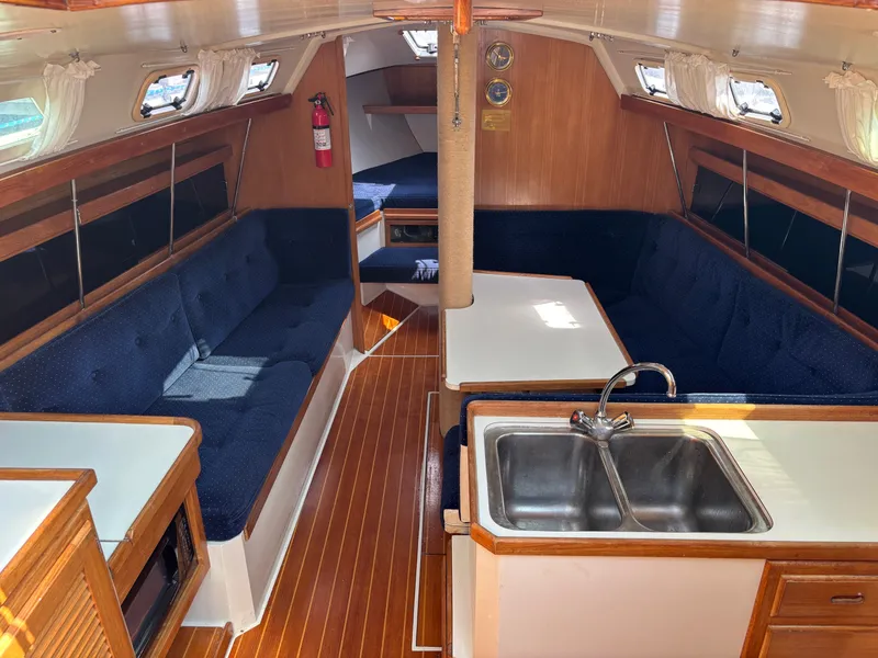 Slide: The Image of Interior of a 1992 Catalina 34 sailboat with wood finish and blue seating. - 43