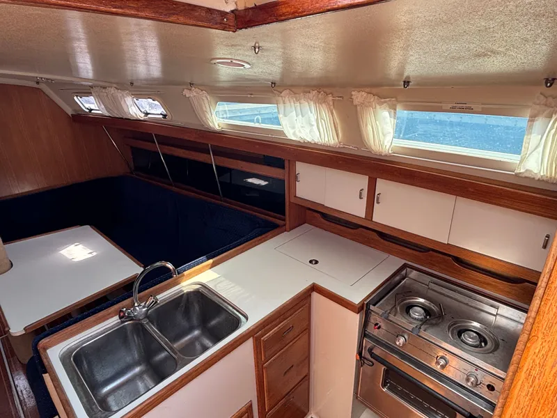Slide: The Image of Interior of 1992 Catalina 34 sailboat kitchen with stove, sink, and dining area. - 44